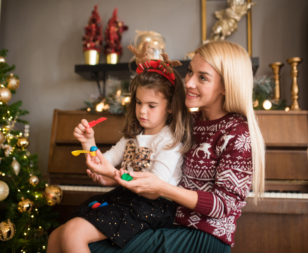 Mother and child sitting next to a Christmas Tree